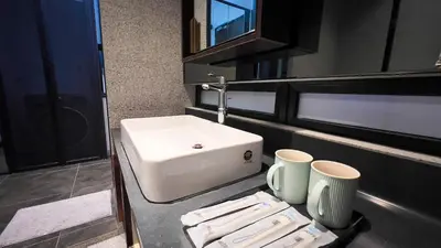 a bathroom with a sink and two cups on a counter at Scarletz Suite KLCC By Light House 4 in Kuala Lumpur