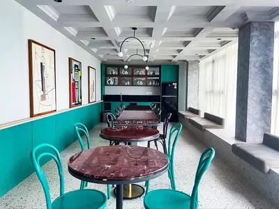 a row of tables and chairs in a room with green walls at Scarletz Suite KLCC By Light House 4 in Kuala Lumpur