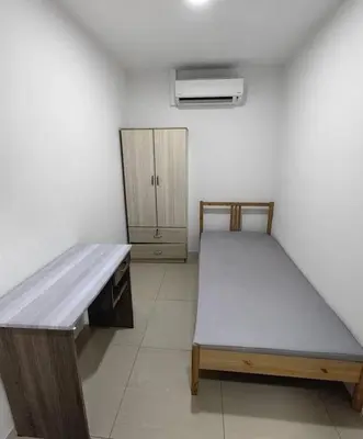 a bedroom with a bed and a wooden desk at Flora Residency Setapak in Kuala Lumpur