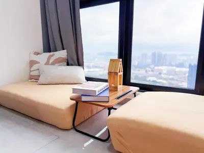 a hotel room with two beds and a table with a book at Agile Delima Bukit Bintang in Kuala Lumpur