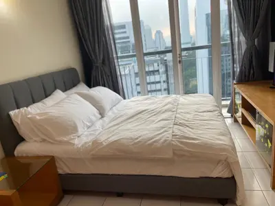 a bed with white sheets in a room with a window at Kuala lampur city centre in Kuala Lumpur