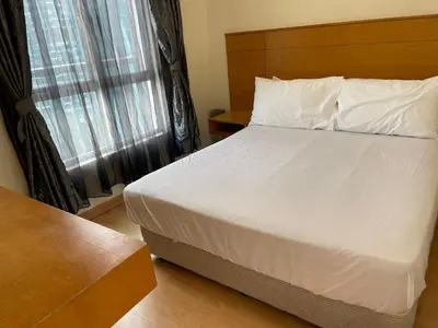 a bedroom with a large white bed and a window at Kuala lampur city centre in Kuala Lumpur