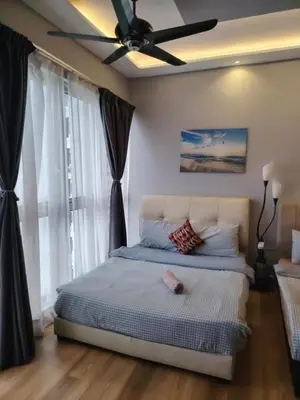 a bedroom with a bed with a ceiling fan at Regalia residence suite view in Kuala Lumpur