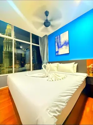 a bedroom with a white bed with a blue wall at Luxury Home Stay by FNF suites in Kuala Lumpur