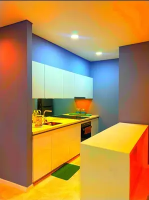 a kitchen with white cabinets and blue walls at Luxury Home Stay by FNF suites in Kuala Lumpur