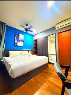 a bedroom with a large bed with a blue wall at Luxury Home Stay by FNF suites in Kuala Lumpur