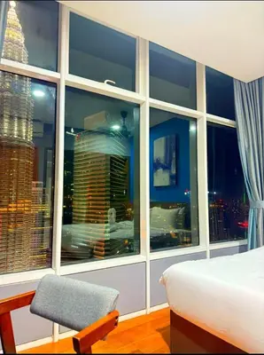 a bedroom with a large window with a bed and a chair at Luxury Home Stay by FNF suites in Kuala Lumpur