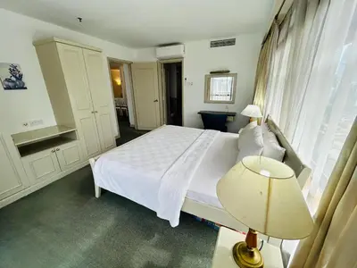 a bedroom with a white bed with a lamp and a window at Holiday Residence at times square kL in Kuala Lumpur