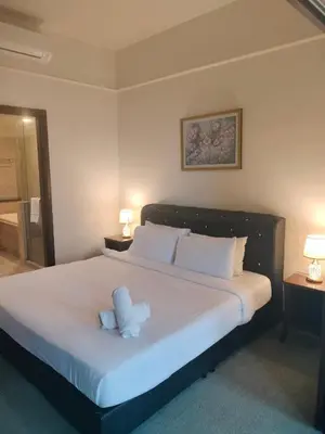 a bedroom with a large white bed with two lamps at Homestay suite at times square KL in Kuala Lumpur
