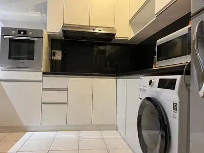 a kitchen with a washing machine and a microwave at Seri bukit ceylon kl in Kuala Lumpur