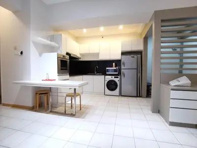 a kitchen with a table and a refrigerator at Seri bukit ceylon kl in Kuala Lumpur