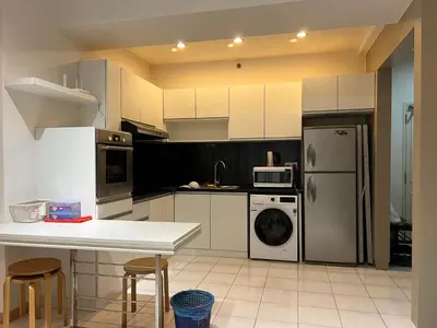 a kitchen with a refrigerator and a table and chairs at Seri bukit ceylon kl in Kuala Lumpur