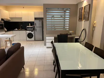 a kitchen and living room with a table and chairs at Seri bukit ceylon kl in Kuala Lumpur