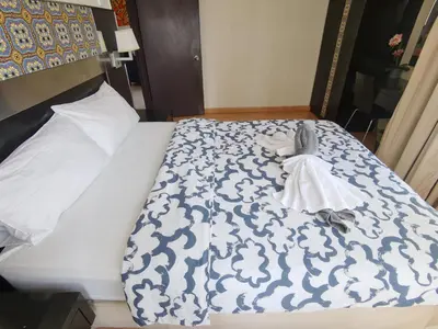 a bed with a blue and white comforter on it at Seri Bukit Ceylon Apartment Bukit Bintang in Kuala Lumpur