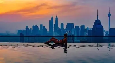a person laying in the water with a city in the background at Regalia residence suite view in Kuala Lumpur