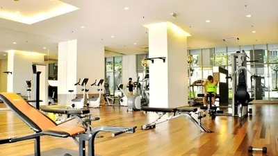 a gym with several treadmills and machines in a room at Regalia residence suite view in Kuala Lumpur