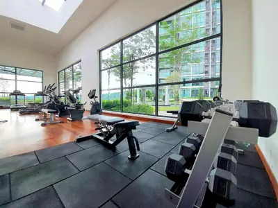 a gym with a large room with treadmills and chairs at 28 Boulevard - Pandan Perdana Cheras KL in Kuala Lumpur