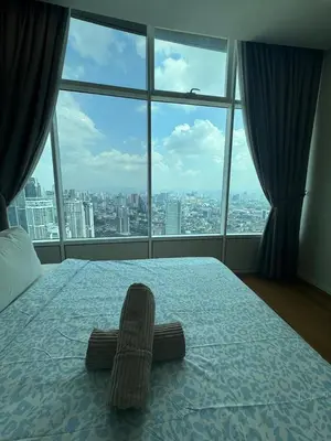 a bedroom with a bed with a large window at Nest In The Sky in Kuala Lumpur