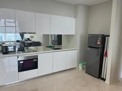 a kitchen with white cabinets and a black refrigerator at Nest In The Sky in Kuala Lumpur