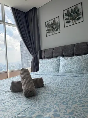a bedroom with a large bed with a large window at Nest In The Sky in Kuala Lumpur