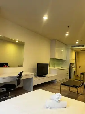 a room with a bed and a desk with a television at Flexy Suite at One Bukit Ceylon Bukit Bintang in Kuala Lumpur