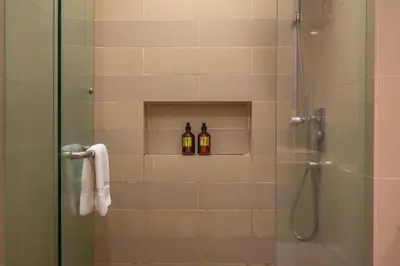 a bathroom with two bottles of alcohol in a shower at Flexy Suite at One Bukit Ceylon Bukit Bintang in Kuala Lumpur