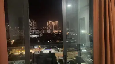 a view of a city at night from a window at The Nest Service Apartment in Kuala Lumpur