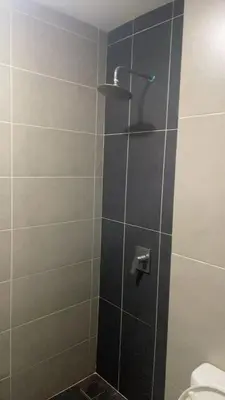 a shower with a glass door with a toilet at The Nest Service Apartment in Kuala Lumpur