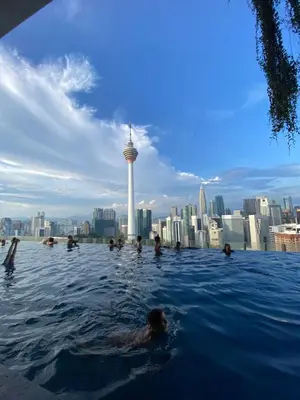 a group of people swimming in a infinity pool with the seattle skyline at Ceylonz Suites by Stayla in Kuala Lumpur
