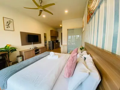 a bedroom with a large white bed with pink pillows at Ceylonz Suites by Stayla in Kuala Lumpur