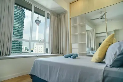 a bedroom with a large bed with a view of a city at A Cozy & Comfy Studio in KLCC with KL Tower View in Kuala Lumpur