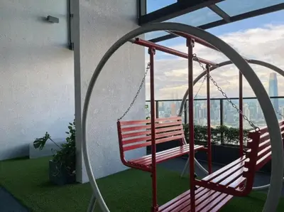 a swinging bench in a room with a window at Trion KL at Level 57 in Kuala Lumpur