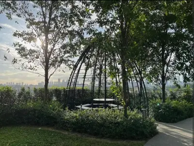 a park with a bench in the middle of trees at Trion KL at Level 57 in Kuala Lumpur