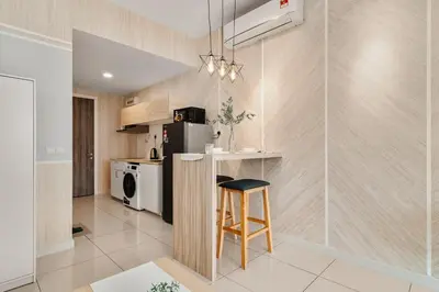 a kitchen with a refrigerator and a stool in a room at Muji Studio Continew by RumaBnB in Kuala Lumpur
