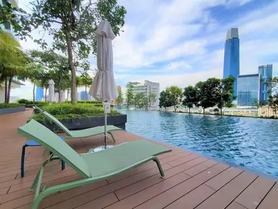 an umbrella and chairs next to a swimming pool at Muji Studio Continew by RumaBnB in Kuala Lumpur