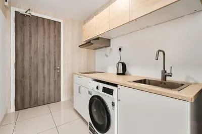 a kitchen with a washing machine and a sink at Muji Studio Continew by RumaBnB in Kuala Lumpur