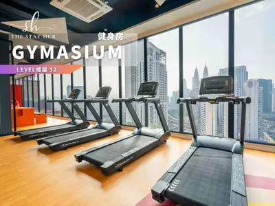 a gym with several treadmills and a view of the city at Majestic Residence - Central KL Stay with Petronas Twin Towers View Sky Pool by The Stay Hub in Kuala Lumpur