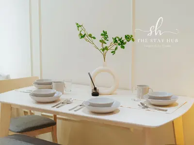 a table with white bowls and plates on it at Majestic Residence - Central KL Stay with Petronas Twin Towers View Sky Pool by The Stay Hub in Kuala Lumpur