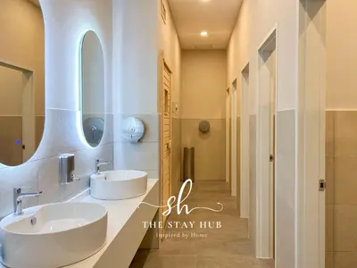 a bathroom with two sinks and two mirrors at Majestic Residence - Central KL Stay with Petronas Twin Towers View Sky Pool by The Stay Hub in Kuala Lumpur