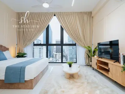 a bedroom with a large bed and a tv at Majestic Residence - Central KL Stay with Petronas Twin Towers View Sky Pool by The Stay Hub in Kuala Lumpur