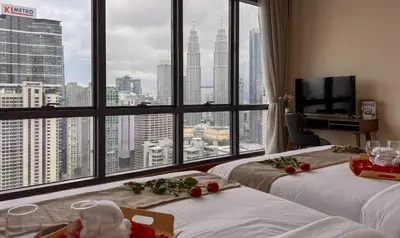 a hotel room with two beds and a large window at Manor Residence KLCC - LV Home in Kuala Lumpur