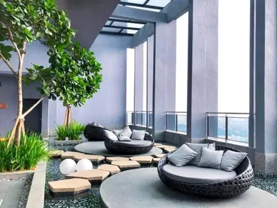 a lobby with two couches and a tree and windows at KLCC Expressionz Couple Suites 1B1B in Kuala Lumpur