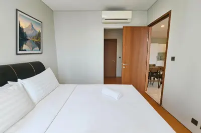 a bedroom with a white bed and a table at Sky Suites KLCC - Luxury Service Apartments Near Petronas Twin Tower in Kuala Lumpur