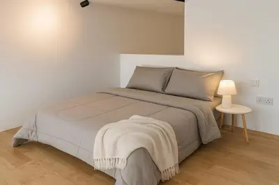 a white bedroom with a bed and a table at Mindful Bangsar Loft KL Sentral Mid Valley The Gardens Pasar Seni in Kuala Lumpur