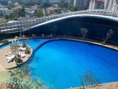 a large blue swimming pool with a bridge over it at ARTE Mont Kiara Designer Suites by HOST CORNER in Kuala Lumpur