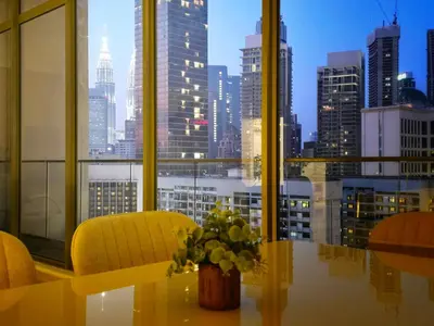a room with a table and chairs and a view of a city at KL Penthouse Skyline View in Bukit Bintang Fairlane in Kuala Lumpur