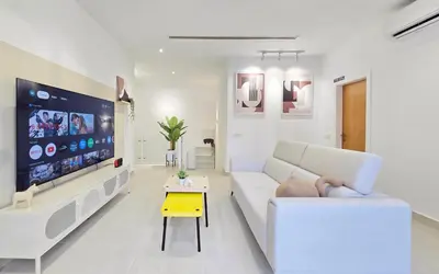 a white living room with a white couch and a tv at KL Penthouse Skyline View in Bukit Bintang Fairlane in Kuala Lumpur
