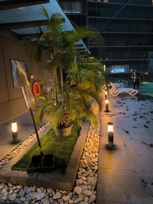 a courtyard with palm trees and lights in a building at Dorsett Luxury Residence KL in Kuala Lumpur
