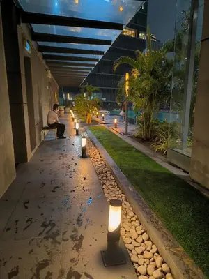 a man sitting on a bench next to a building with candles at Dorsett Luxury Residence KL in Kuala Lumpur
