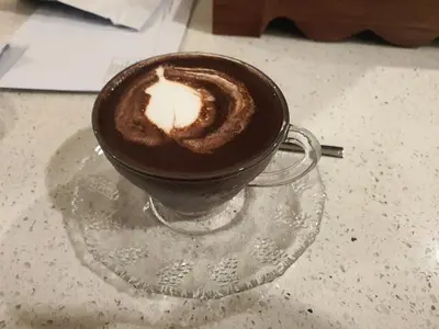 a cup of coffee with a lit candle in it at Kiaramas Gateway Residence in Kuala Lumpur